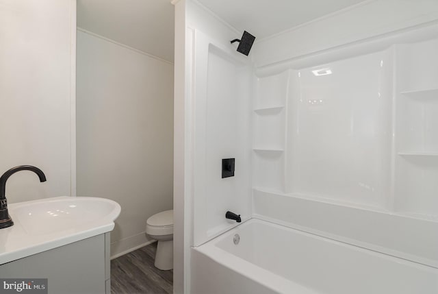 full bathroom with hardwood / wood-style floors, vanity, shower / bathing tub combination, toilet, and ornamental molding