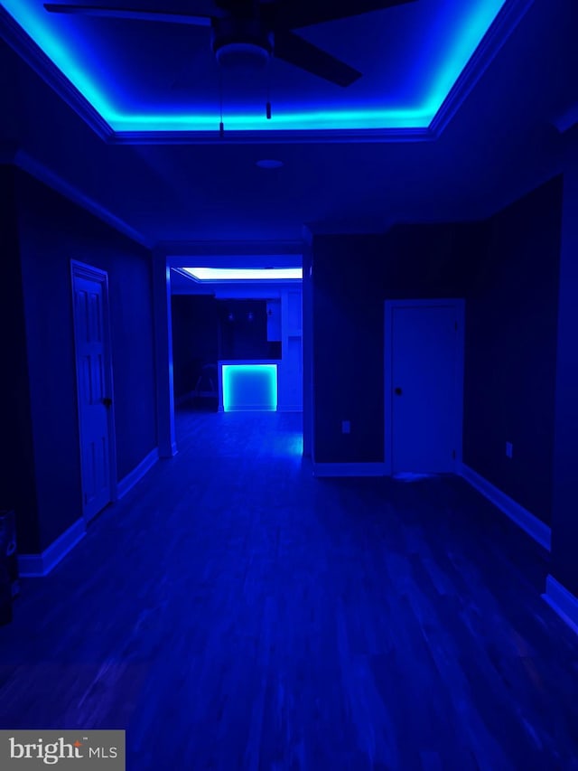 unfurnished room featuring hardwood / wood-style floors, ceiling fan, a raised ceiling, and crown molding