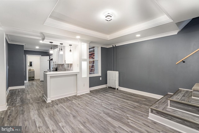 kitchen with white cabinets, dark hardwood / wood-style floors, kitchen peninsula, and radiator