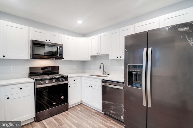 kitchen featuring light hardwood / wood-style floors, white cabinetry, sink, and appliances with stainless steel finishes