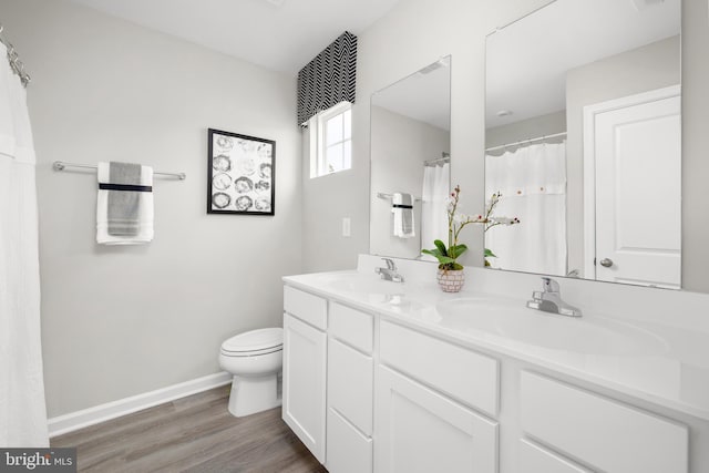 bathroom with toilet, vanity, and hardwood / wood-style flooring