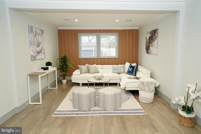 living room featuring crown molding and light hardwood / wood-style flooring