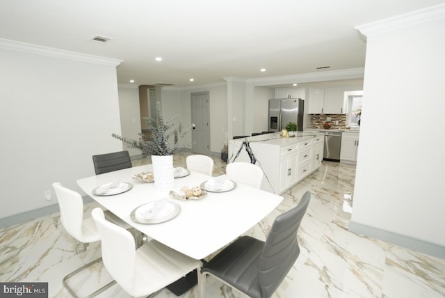 dining area featuring decorative columns and crown molding