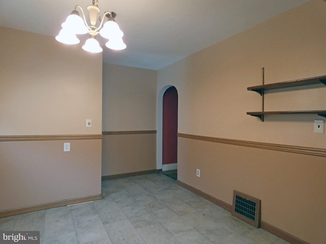 spare room featuring an inviting chandelier