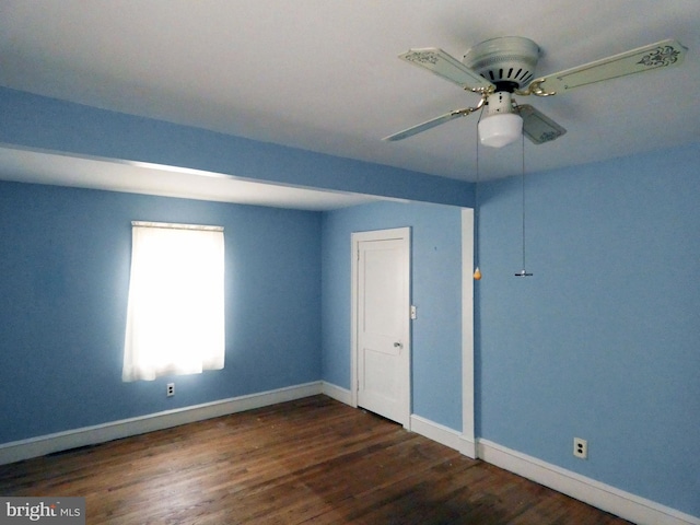 spare room featuring ceiling fan and dark wood-type flooring