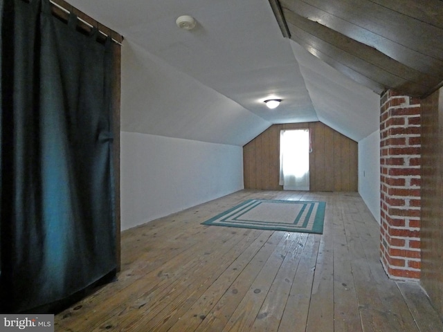 additional living space with vaulted ceiling and light wood-type flooring