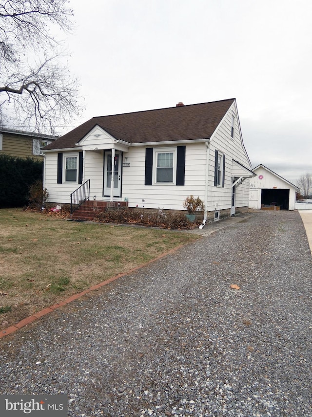 ranch-style house featuring an outbuilding, a garage, and a front lawn