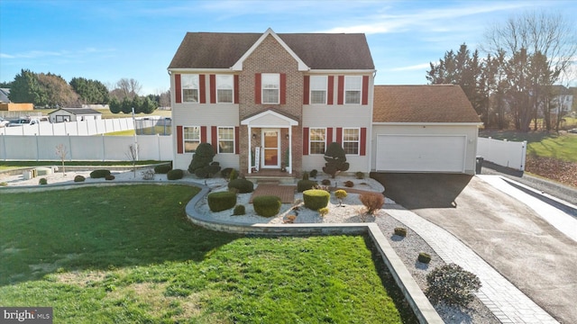 colonial inspired home with a front lawn and a garage