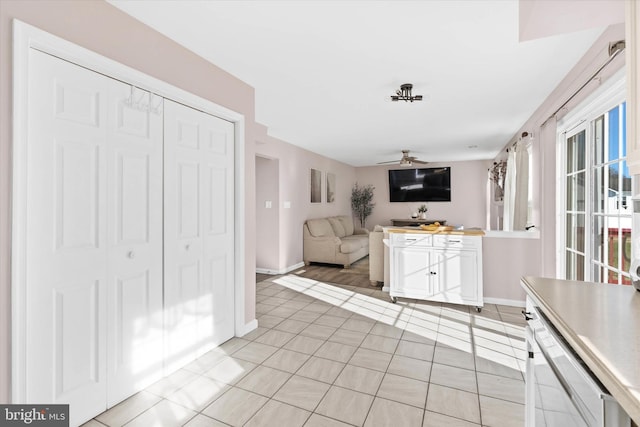 kitchen with white cabinets, ceiling fan, and light tile patterned floors