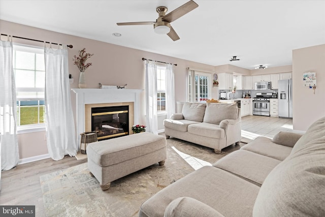 living room featuring ceiling fan and light hardwood / wood-style floors