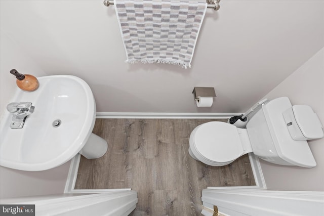 bathroom featuring toilet, wood-type flooring, and sink