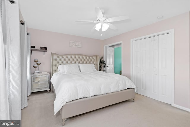 bedroom with ceiling fan, a closet, and light carpet