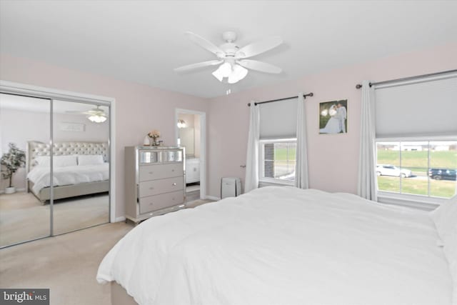 bedroom featuring ceiling fan, light carpet, and a closet