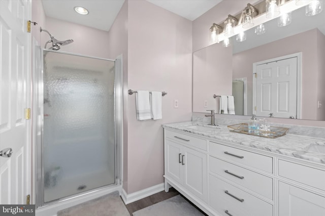 bathroom featuring hardwood / wood-style floors, vanity, and a shower with door