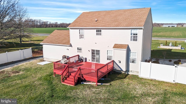 rear view of property featuring a wooden deck and a yard