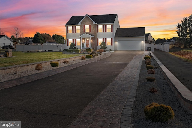 view of front of home featuring a garage and a yard