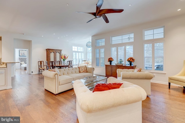 living room with light hardwood / wood-style flooring and ceiling fan