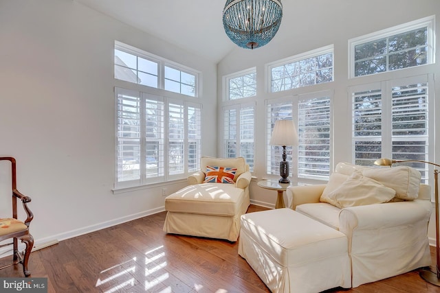 sitting room with wood-type flooring and high vaulted ceiling