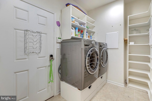 clothes washing area featuring light tile patterned floors and washer and clothes dryer