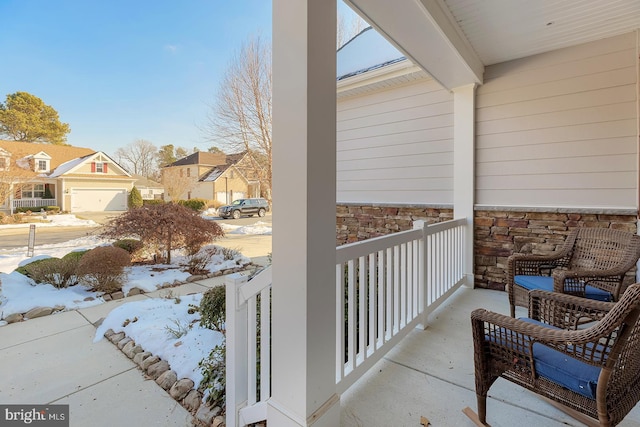 snow covered back of property with covered porch