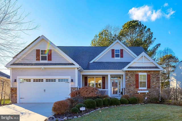 view of front of house featuring a porch, a garage, and a front yard