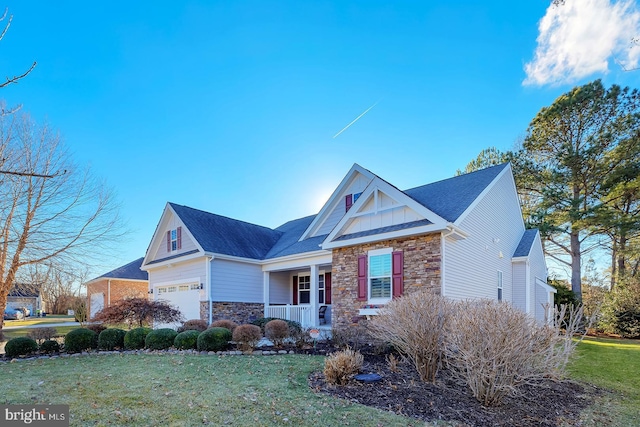 view of front of property featuring a garage, a front yard, and a porch