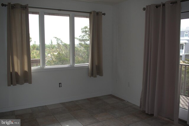 unfurnished room with tile patterned flooring and a healthy amount of sunlight