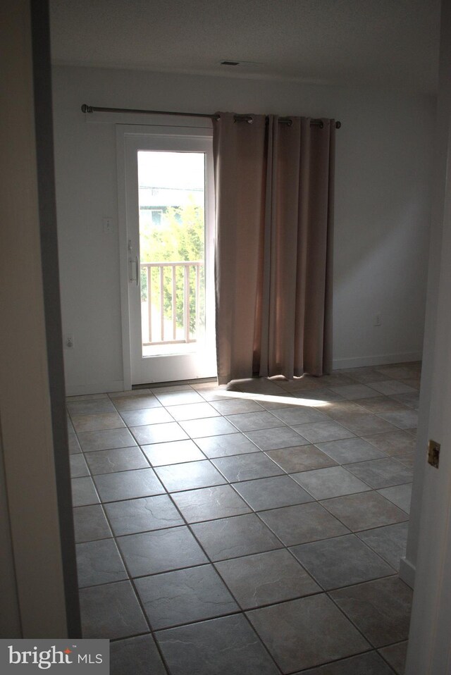 unfurnished room with light tile patterned flooring