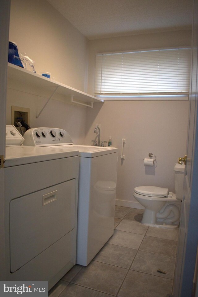 laundry room with light tile patterned floors and washing machine and clothes dryer