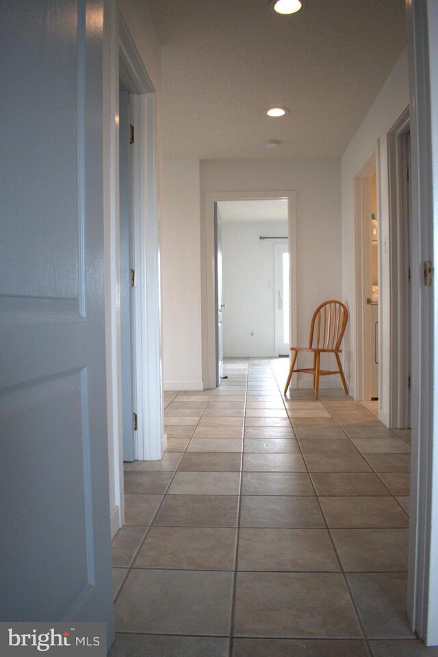 hall with tile patterned floors