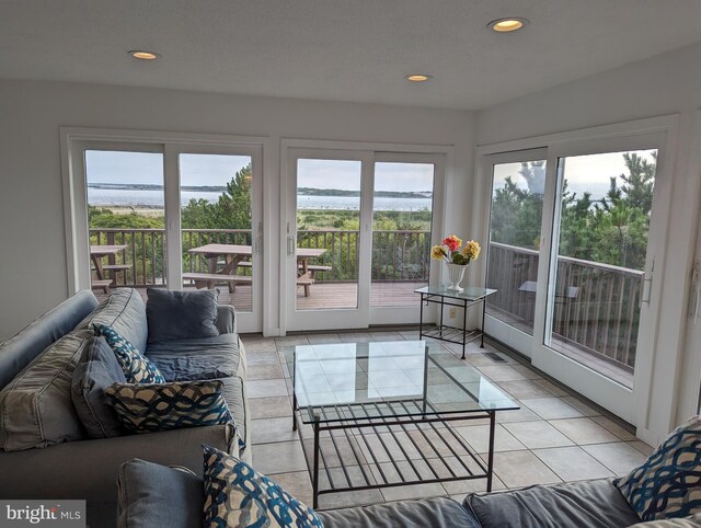 sunroom with a water view and a wealth of natural light