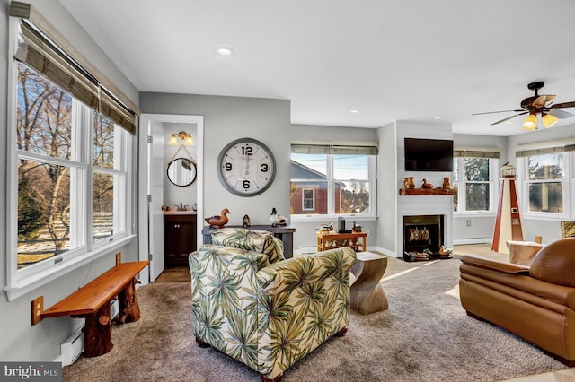 carpeted living room with a healthy amount of sunlight and a baseboard heating unit