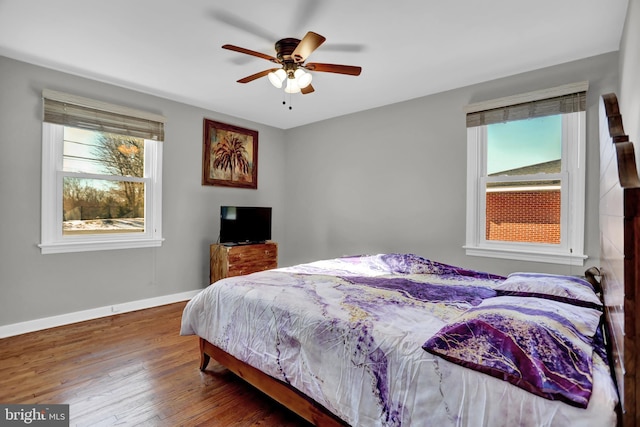 bedroom featuring cooling unit, ceiling fan, hardwood / wood-style floors, and multiple windows