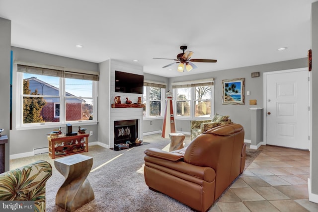 living room featuring light tile patterned flooring, ceiling fan, and a baseboard radiator