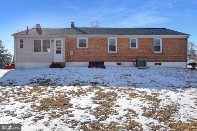 snow covered house with central air condition unit