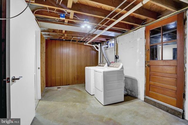 basement with washer and dryer and wood walls