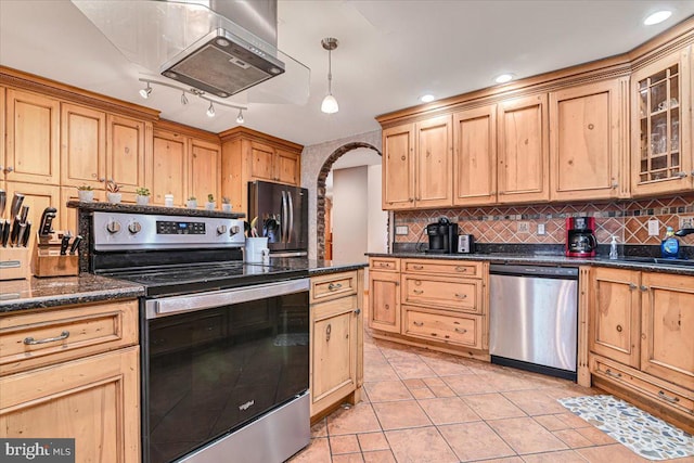 kitchen featuring backsplash, light tile patterned floors, stainless steel appliances, and decorative light fixtures