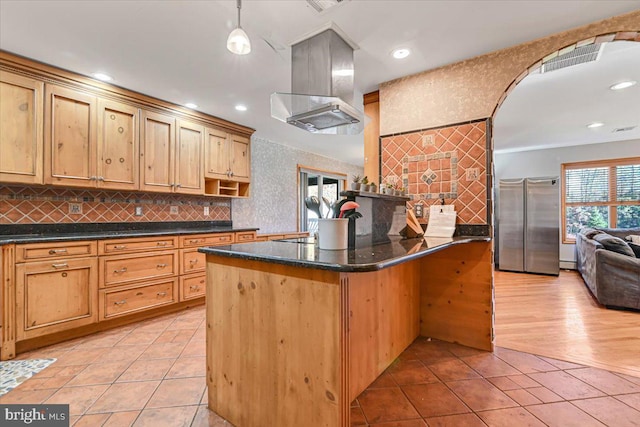 kitchen with stainless steel refrigerator, light hardwood / wood-style flooring, dark stone counters, pendant lighting, and island range hood