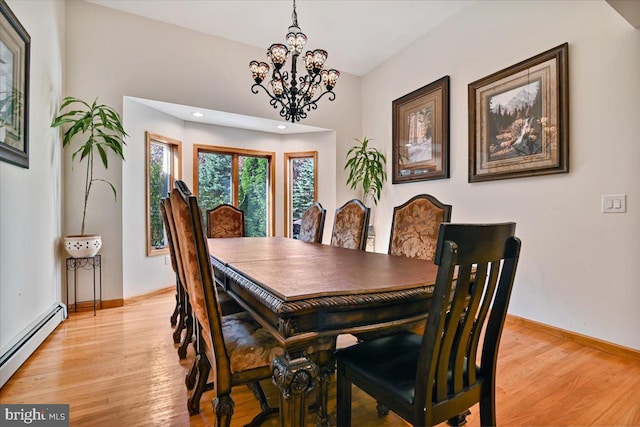 dining room with light hardwood / wood-style floors, an inviting chandelier, and baseboard heating