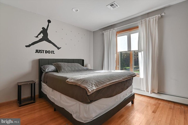 bedroom featuring wood-type flooring and a baseboard radiator