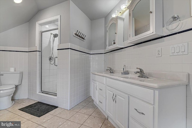 bathroom featuring tile patterned floors, vaulted ceiling, tile walls, and walk in shower