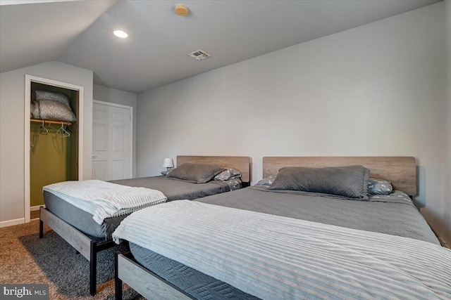 carpeted bedroom featuring a spacious closet, a closet, and lofted ceiling