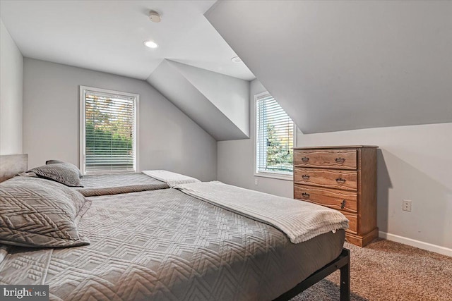 bedroom featuring light colored carpet, multiple windows, and lofted ceiling