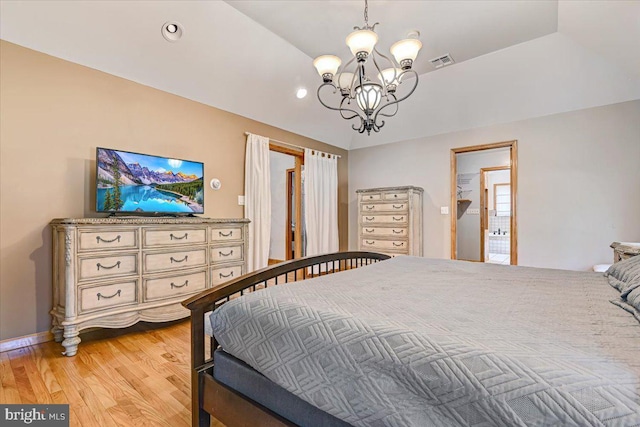 bedroom featuring an inviting chandelier, vaulted ceiling, and light hardwood / wood-style flooring