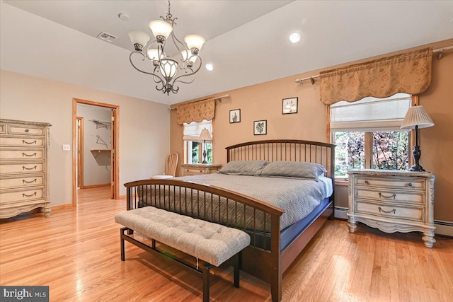 bedroom featuring vaulted ceiling, a baseboard radiator, light hardwood / wood-style flooring, and a notable chandelier