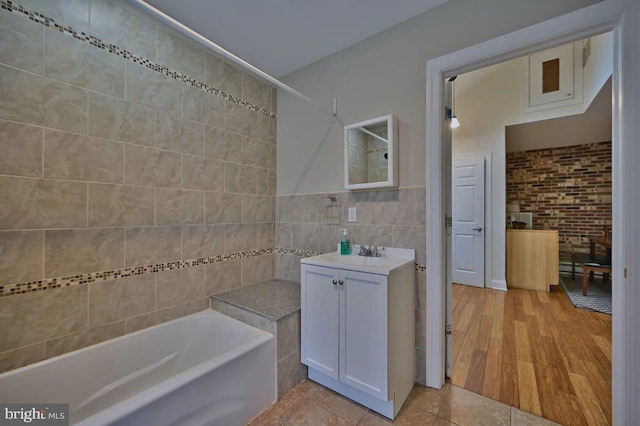 bathroom featuring vanity, wood-type flooring, and tile walls