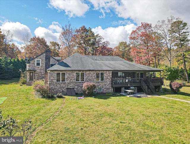 rear view of house featuring a yard and a deck