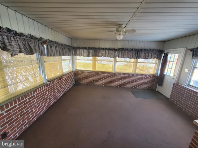 unfurnished sunroom featuring a wealth of natural light and ceiling fan