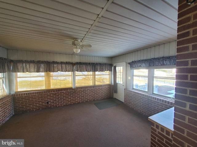 unfurnished sunroom with ceiling fan