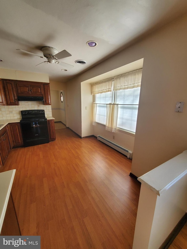 kitchen with black electric range oven, backsplash, a baseboard heating unit, ceiling fan, and light hardwood / wood-style floors